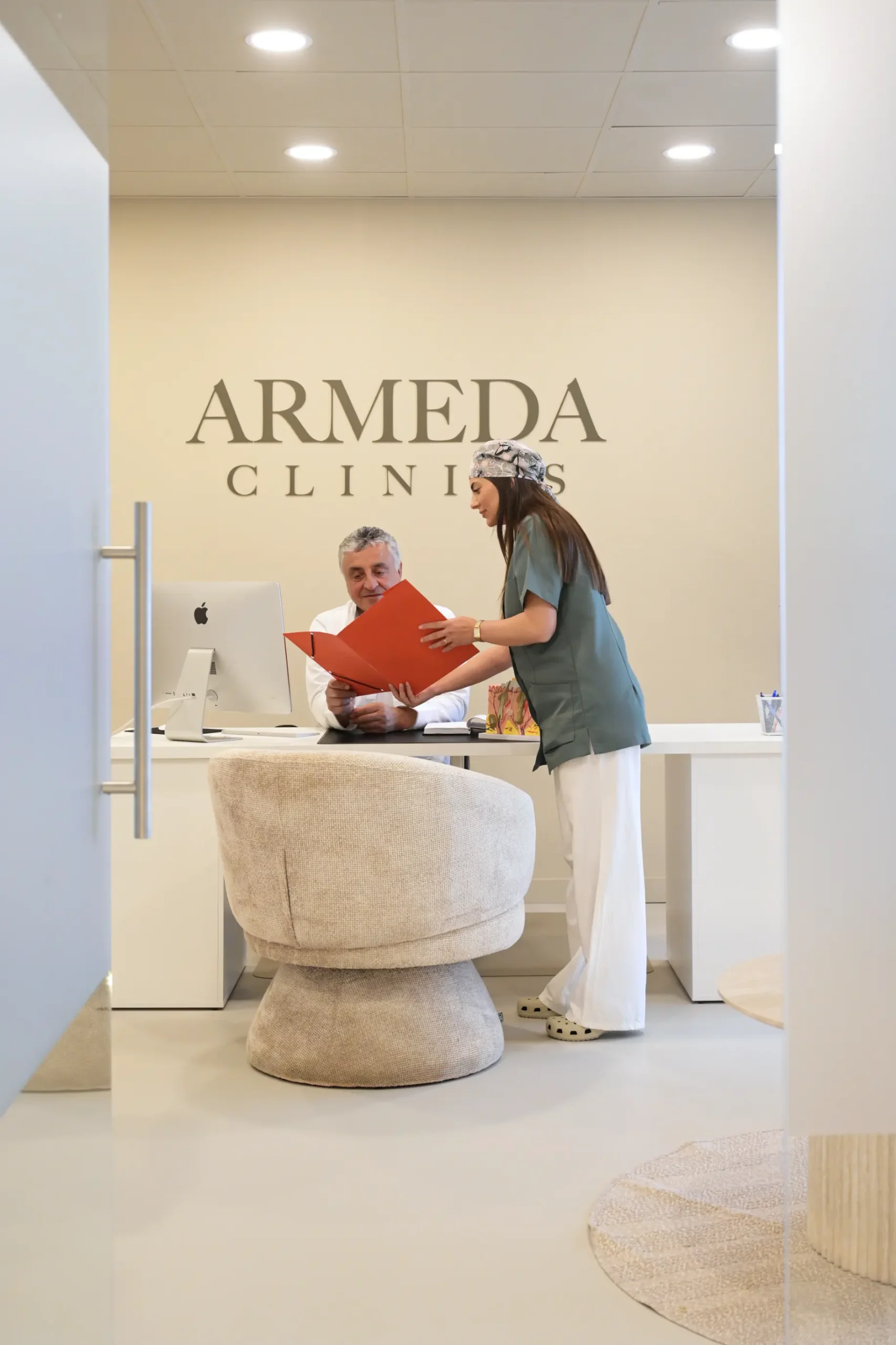 Medewerker bespreekt dossier met specialist in spreekkamer bij Armeda Clinics in Eindhoven